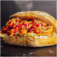 Pulled chicken in een huisgemaakte sticky koreaanse gochujangsaus. Pittig en vol van smaak, in balans gebracht met zoetzure komkommer en rode ui. Afgegarneerd met sesam voor smaak en textuur.