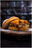 Malse pulled chili chicken rijk gemarineerd in onze huisgemaakte chillisaus, gesmolten cheddar, verse ijsbergsla en afgewerkt met onze eigen chillisaus<br><i> voor een extra kick kun je extra sambal toevoegen.</i> 